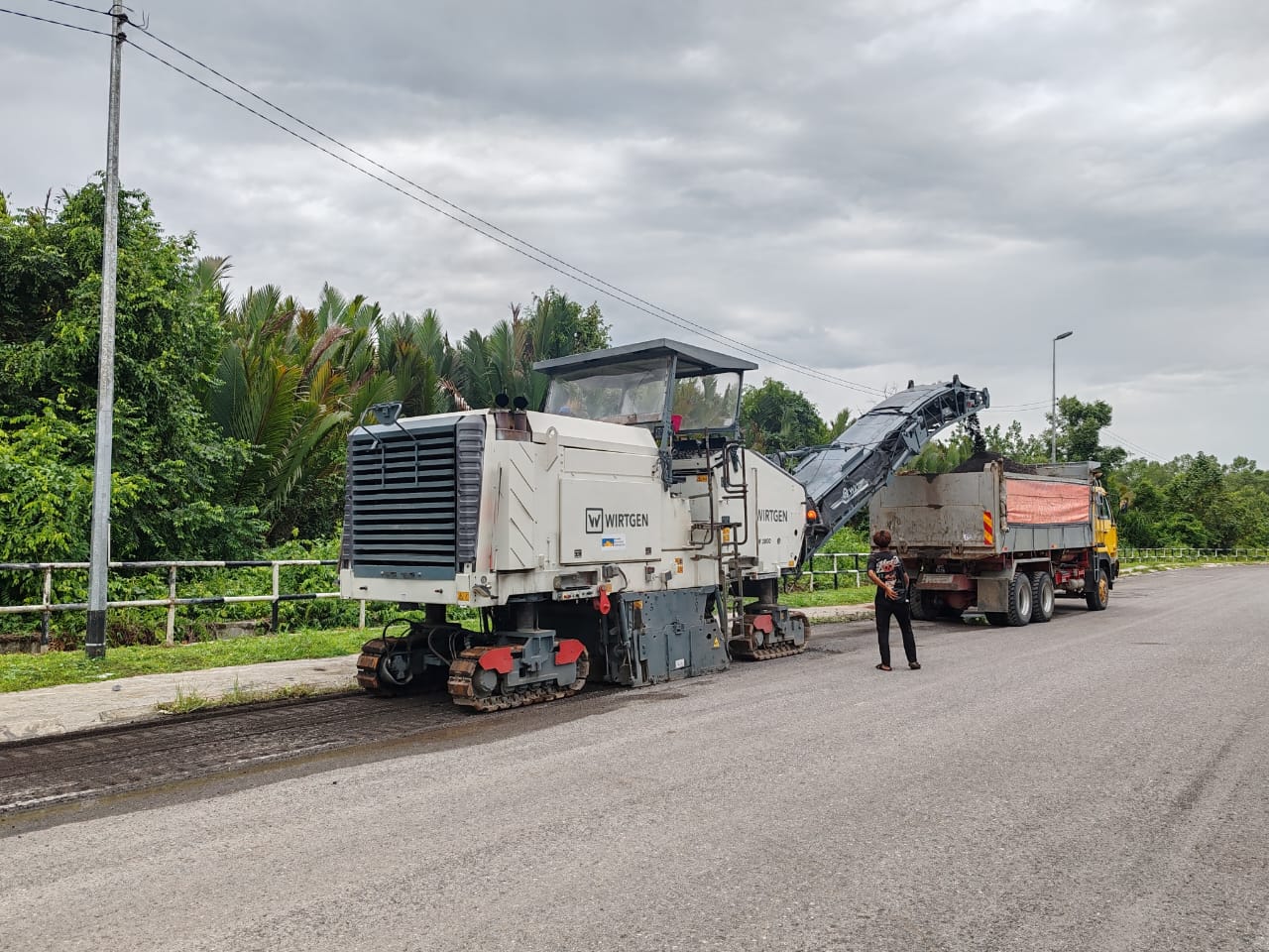 Wirtgen cold milling machine removing the old road surface into a tipper truck