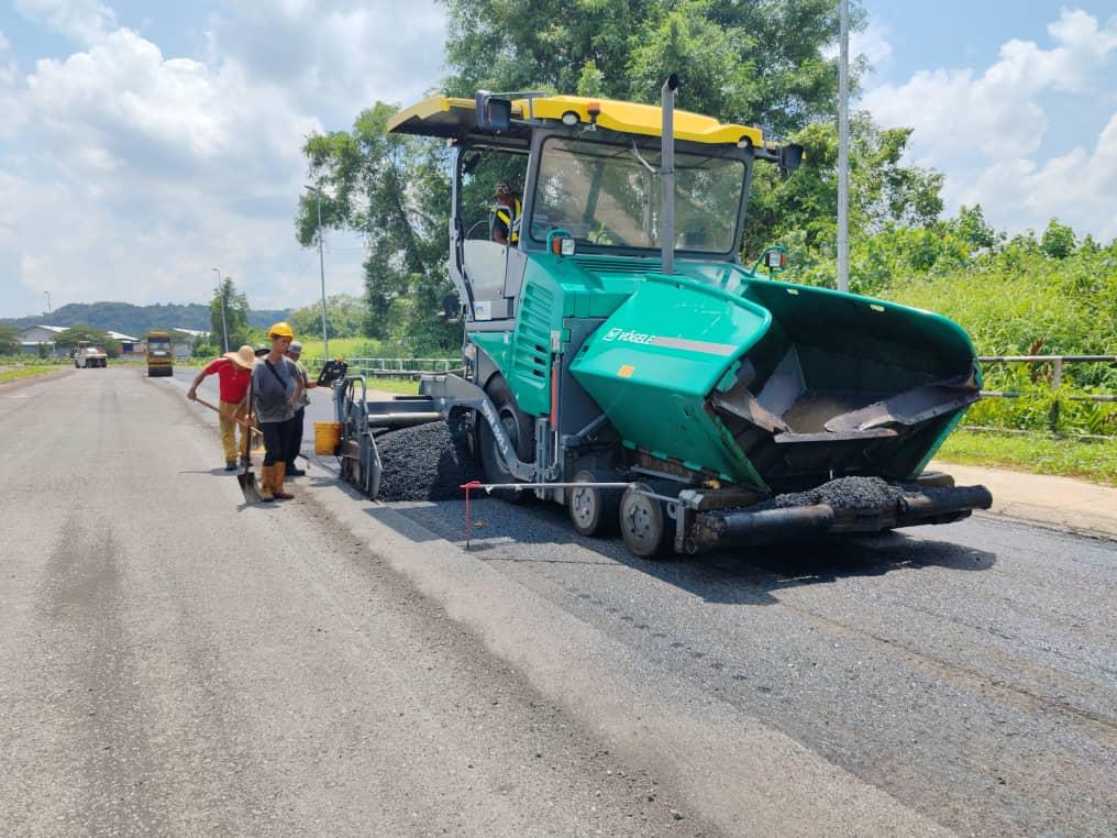 Vögele paver laying premix asphalt with crew alongside